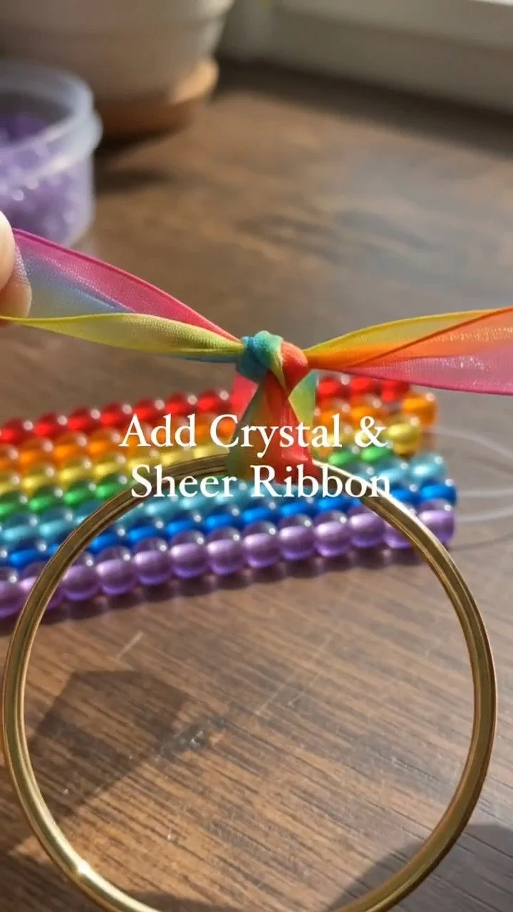 Ein Mix aus bunten Ponyperlen und einem Kristallanhänger kreiert einen fröhlichen Regenbogen-Sonnenfänger, der jedes sonnige Fenster zum Strahlen bringt.